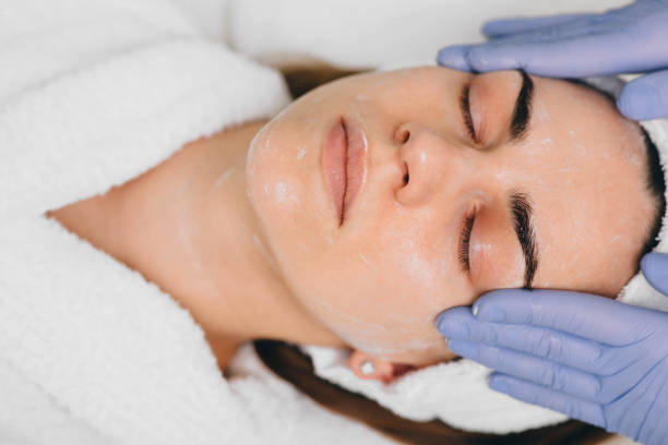 beautiful woman having her face pampered at beauty salon by her beautician